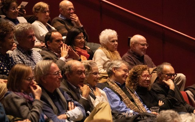 Audience members listen to the conversation.